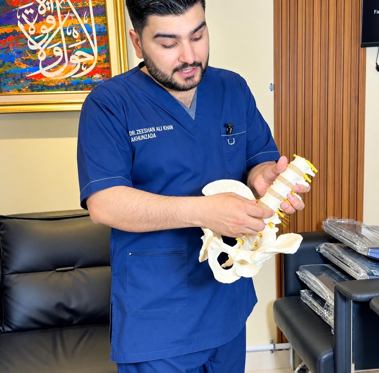 Dr. Zeeshan Ali Khan Akhunzada explaining the spine with an anatomical model